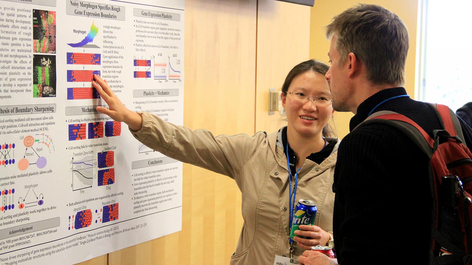 Photo of researcher explaining her poster