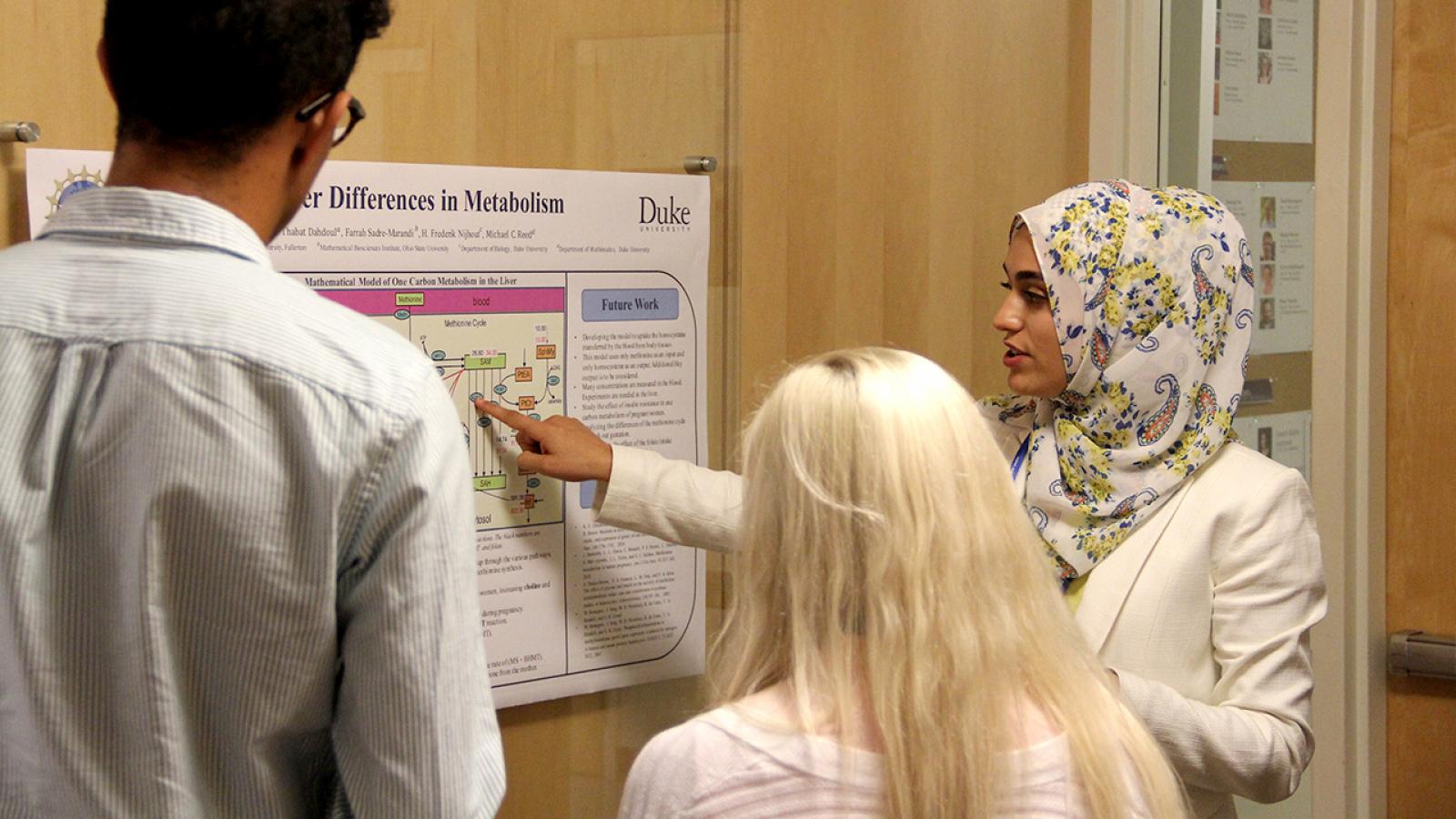 An REU student presenting her research poster